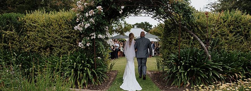 A beautiful rustic wedding ceremony at an event venue in Melbourne, adorned with wisteria flowers.